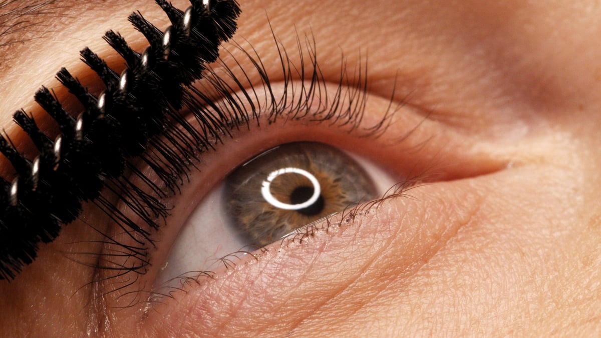 Woman getting eyelashes lamination treatment in beauty salon
