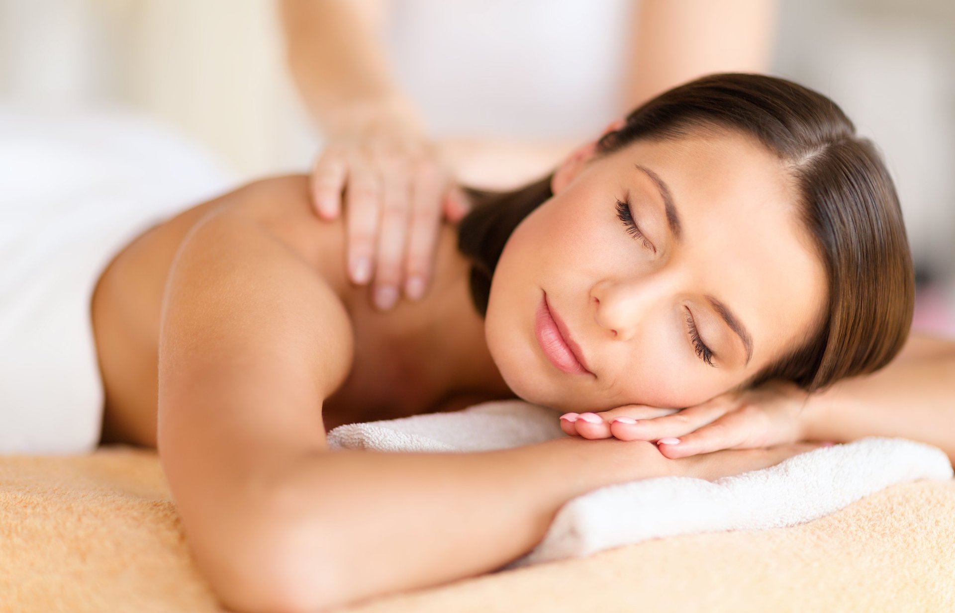 health, beauty, resort and relaxation concept - beautiful woman with closed eyes in spa salon getting massage