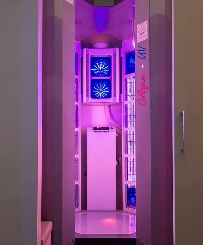 Futuristic booth interior with purple and blue neon lighting, featuring blue neon fan displays and a pink illuminated interior